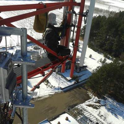 alpinista wykonuje usuwanie awarii i poprawki na wieży przekaźnikowej